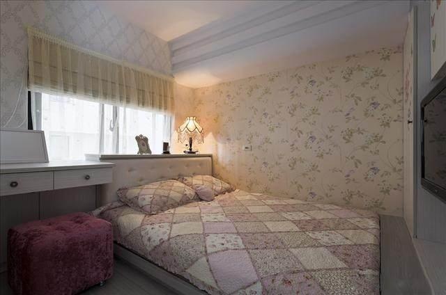 很温馨的卧室,周围墙面都贴了墙纸,床头窗户的的窗帘是卷帘设计.